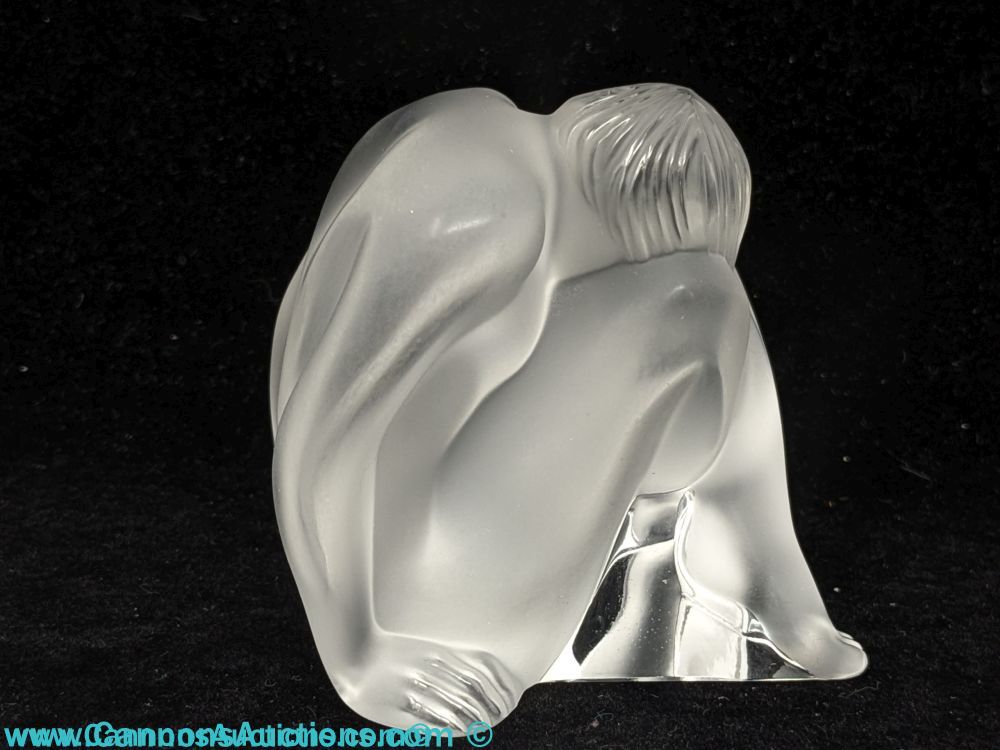 Lalique Paris signed satin crystal “Nu Assis” figurine depicting a seated female nude with head resting on knees, frosted crystal with polished base, approximately 2.5 inches tall, includes original Lalique box.