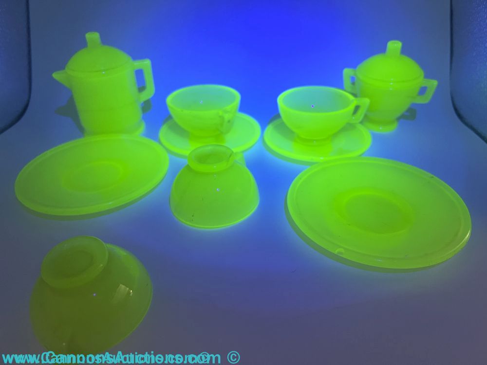 Vintage UV-reactive vaseline (uranium) glass child’s tea set, 10 pieces, glowing neon green under blacklight; tallest piece approx. 3.5 in.