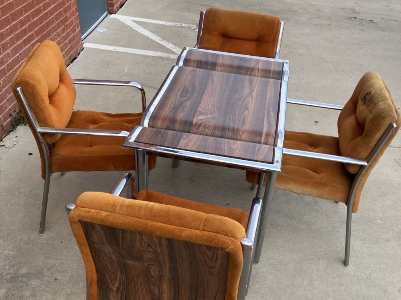 Vintage Chromcraft faux burl woodgrain dining table with chrome trim, paired with four matching chrome-framed chairs upholstered in golden velvet.