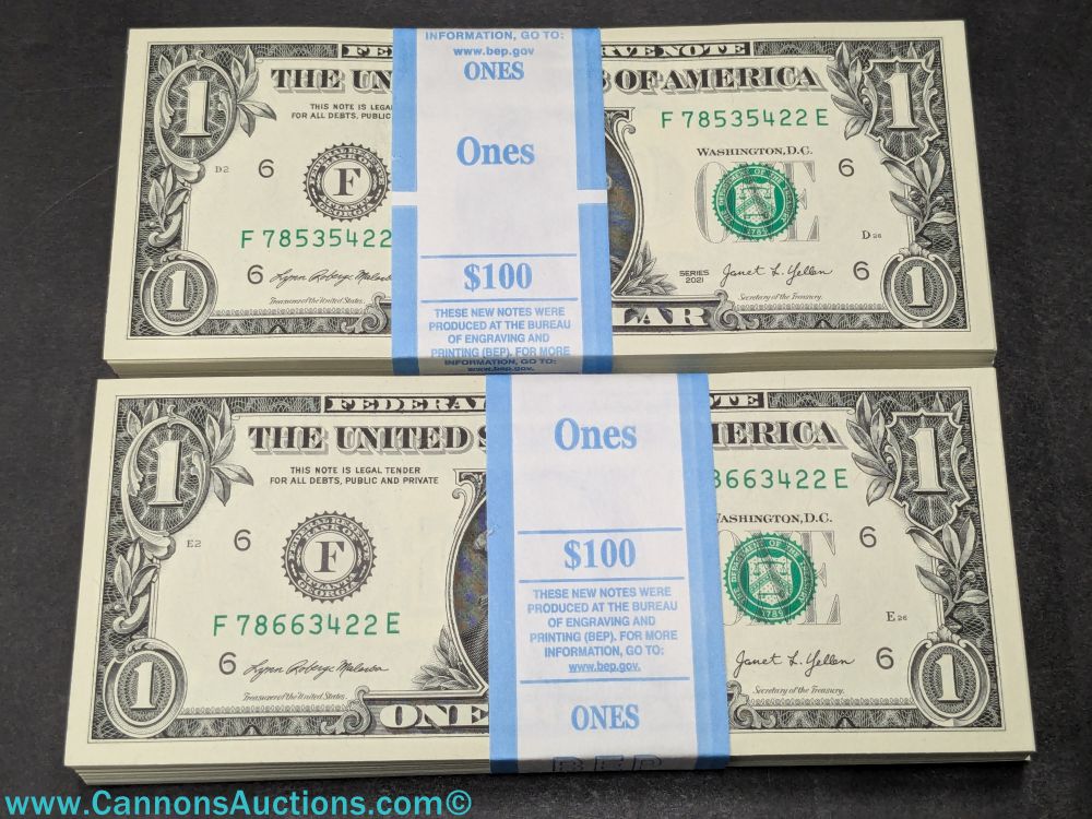 Two $100 packs of uncirculated sequential Series 2021 one-dollar bills with blue paper bank straps.