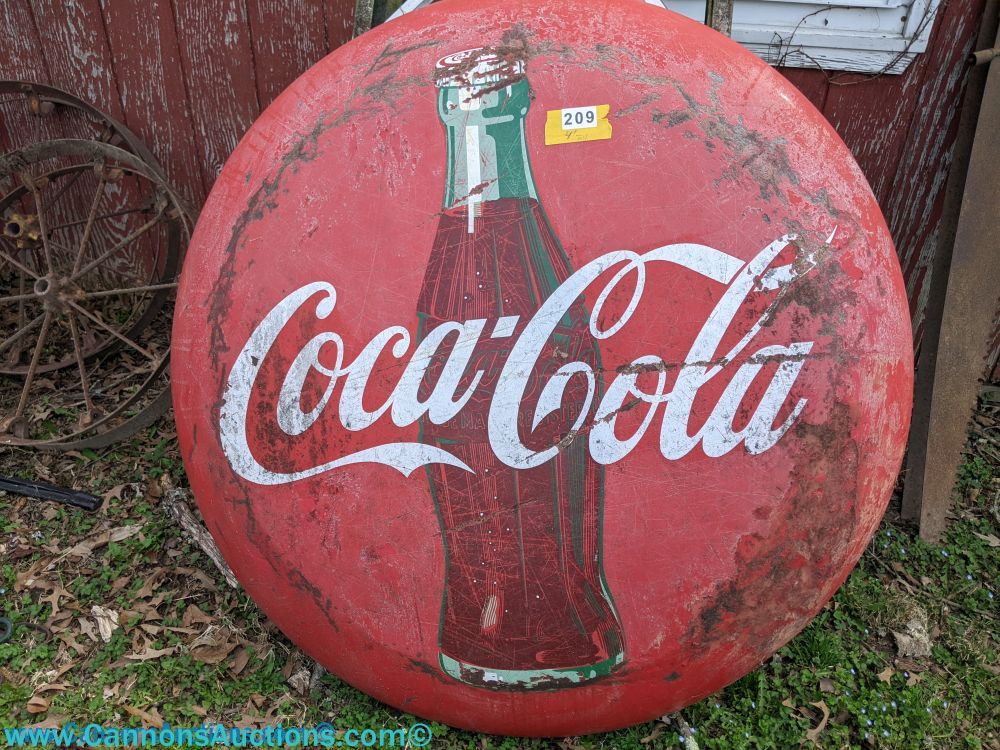 Vintage porcelain Coca-Cola advertising sign with bottle graphic and white script logo, round form measuring 4 feet in diameter