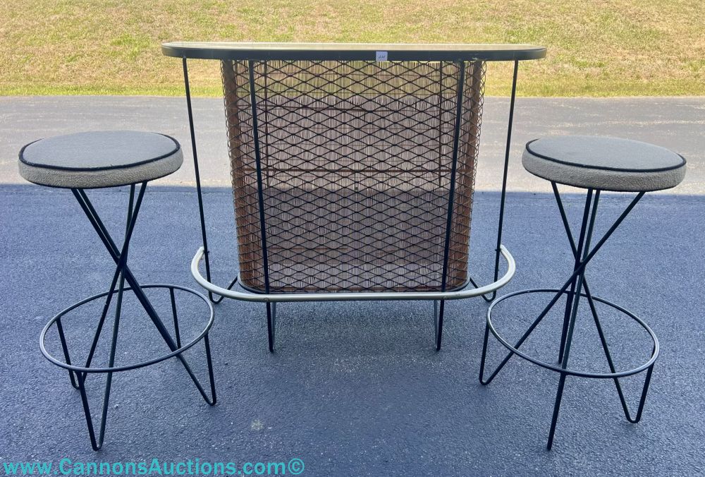 Mid-Century Modern wrought iron bar with matching stools, featuring a black metal frame, mesh front panel, and upholstered round seats; bar measures 39 inches high by 48 inches wide by 16 inches deep.