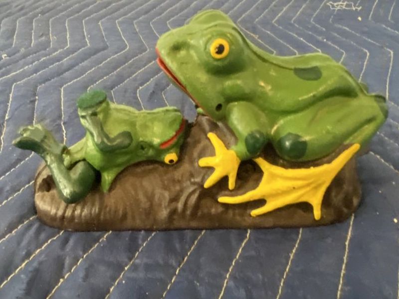 Cast iron frog mechanical bank with two green frogs on a log, yellow webbed feet, and painted details