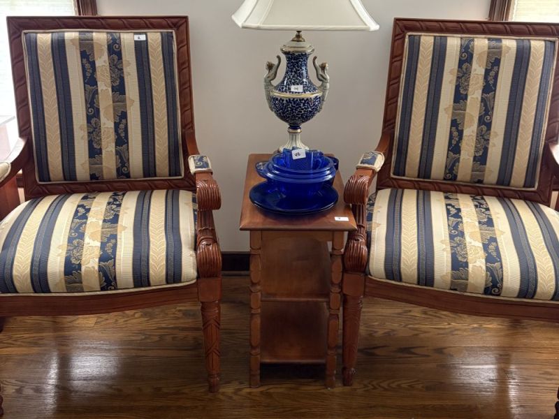 Pair of carved wood armchairs with striped blue and beige upholstery beside a small wood side table with blue and white table lamp and cobalt blue glassware, Hillenwood Dr Powhatan VA estate auction