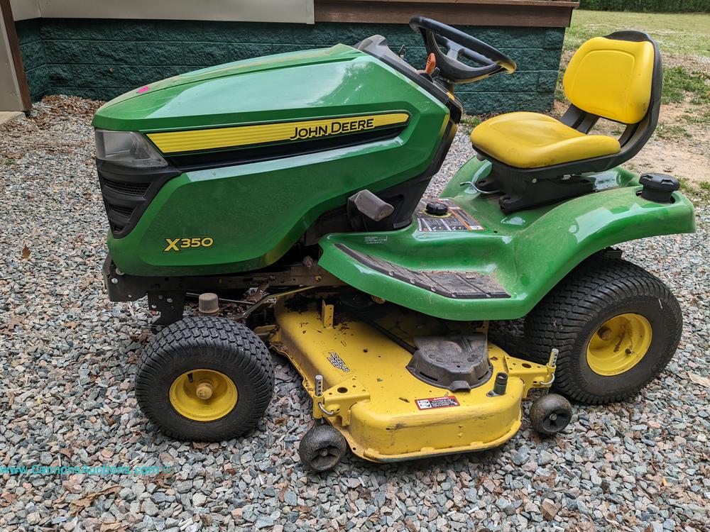John Deere X350 riding lawn mower with yellow seat and mower deck, good working condition, showing 53.7 hours, featured in the Powhatan VA onsite estate auction.