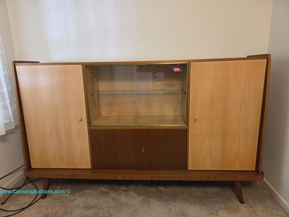 Mid-Century wooden cabinet with glass display section, sliding or hinged storage doors, and tapered legs.