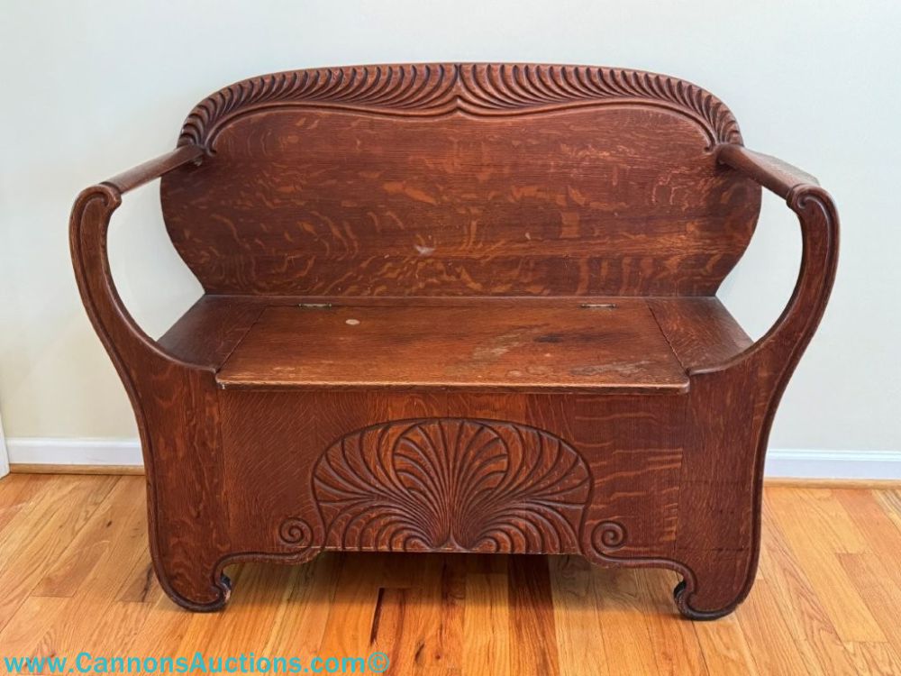 Antique quarter sawn oak hall bench with carved details, curved arms, lift-up storage seat, and original finish