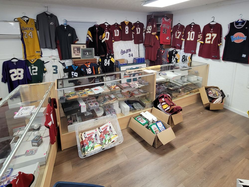 Online sports auction display in Dinwiddie featuring football, basketball, baseball, and hockey jerseys, sports cards, memorabilia, display cases, and collectibles.