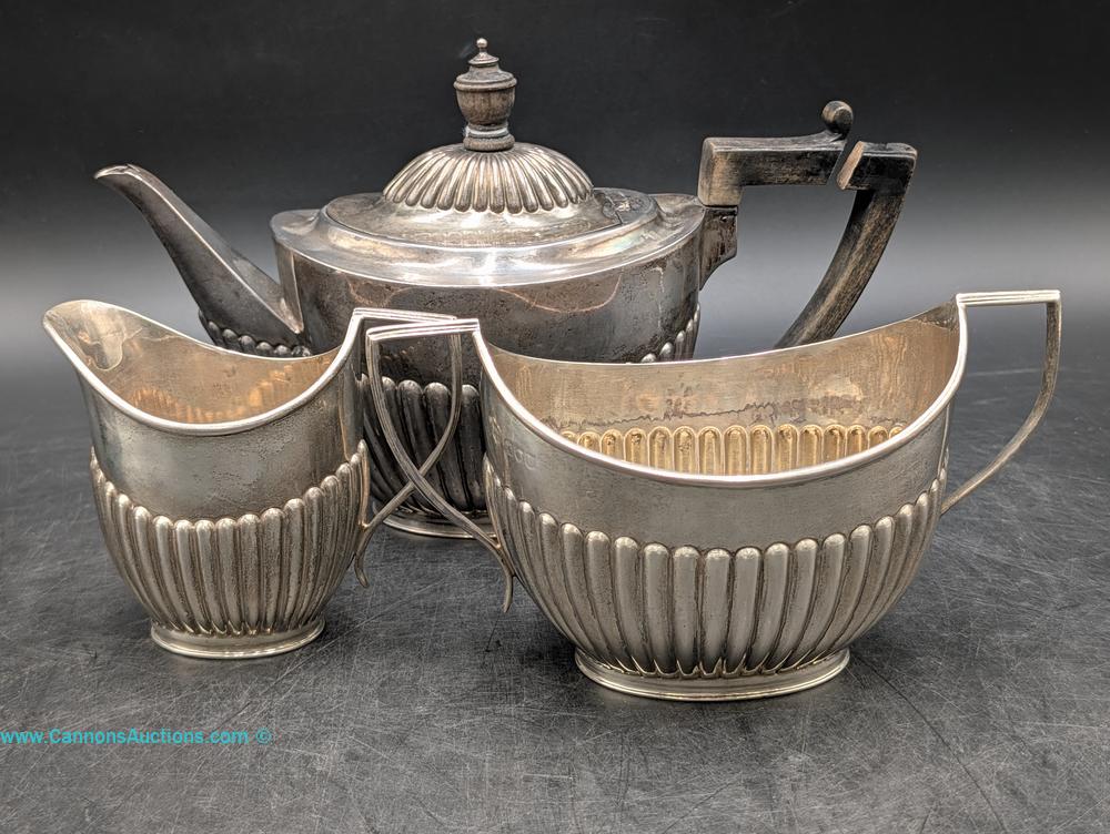 Late Victorian three-piece English sterling silver tea set by Goldsmiths & Silversmiths Co., London 1895, with teapot, creamer, and sugar bowl
