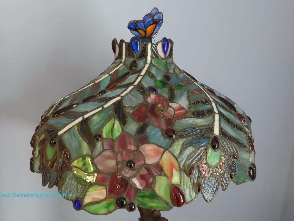 Art Nouveau-style Tiffany stained glass table lamp with floral and butterfly shade, tree-form base, and two pull chains