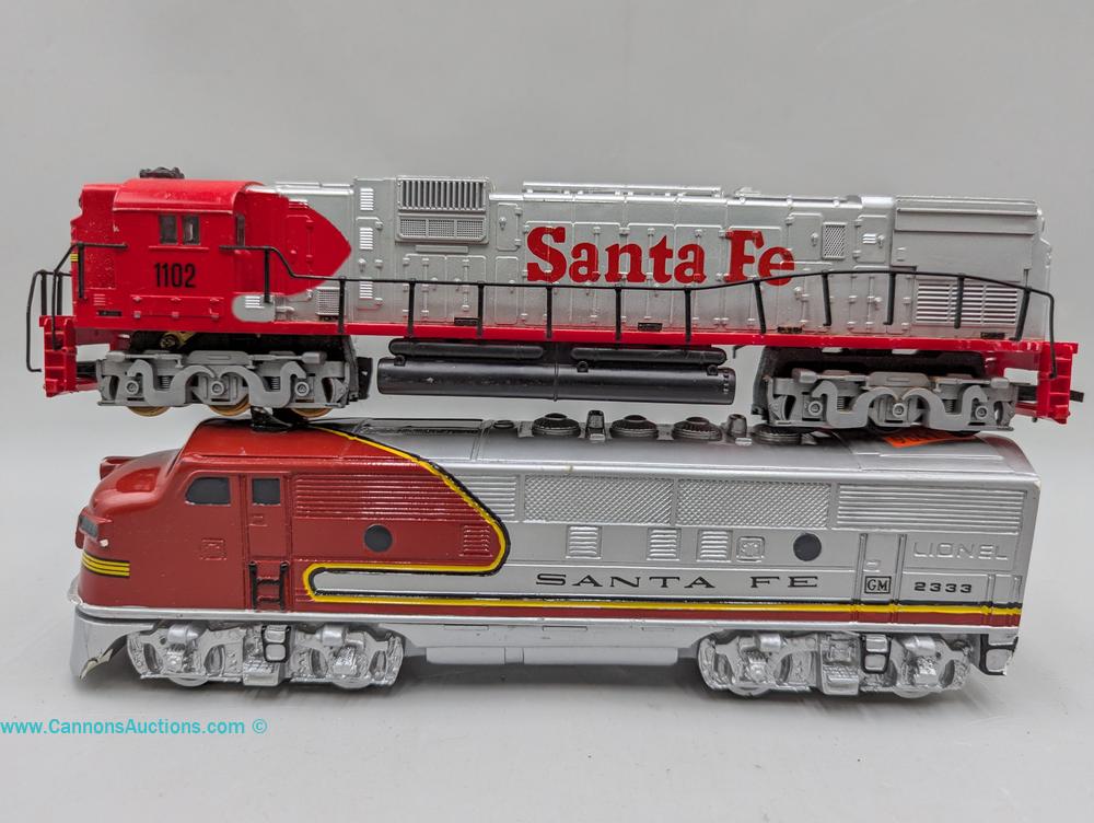 Two Santa Fe model locomotives, including a Lionel 2333 diesel locomotive and Tyco 1102 diesel locomotive.