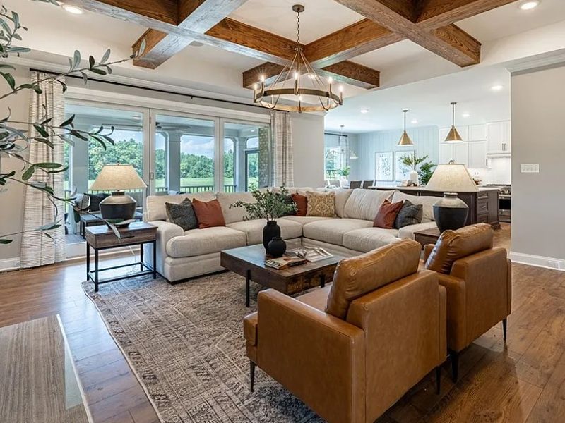 Like-new sectional sofa, leather armchairs, area rug, tables, lamps, and home décor in a Richmond model home staging auction