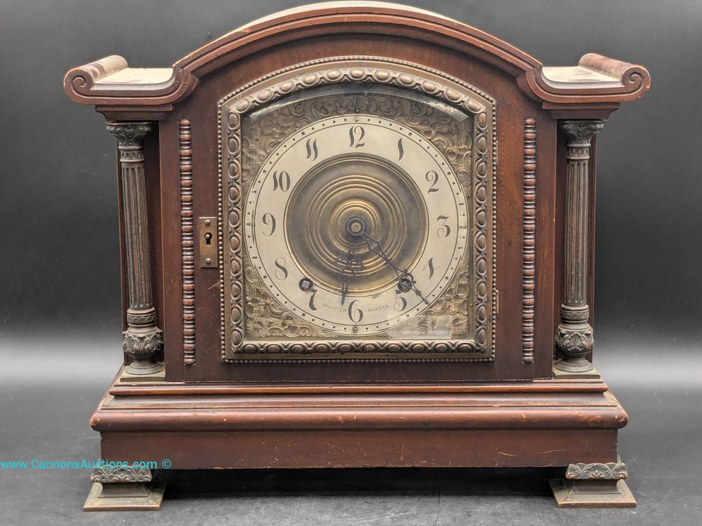Tiffany & Co. Makers bracket clock with mahogany case, ornate brass dial, Roman numerals, and decorative column details