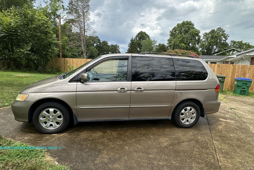 2004 Honda Odyssey EX minivan in beige with alloy wheels and tinted rear windows, odometer showing 152,242 miles.