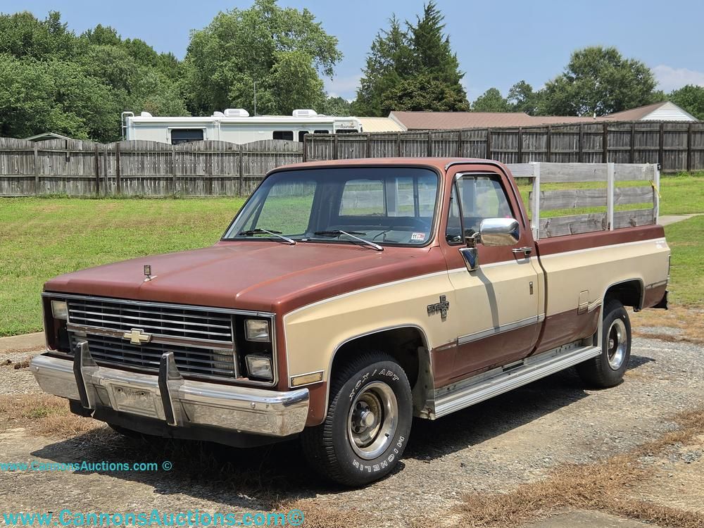 Chevrolet Silverado 10 pickup truck with two-tone brown and cream exterior and wooden side rails on the bed