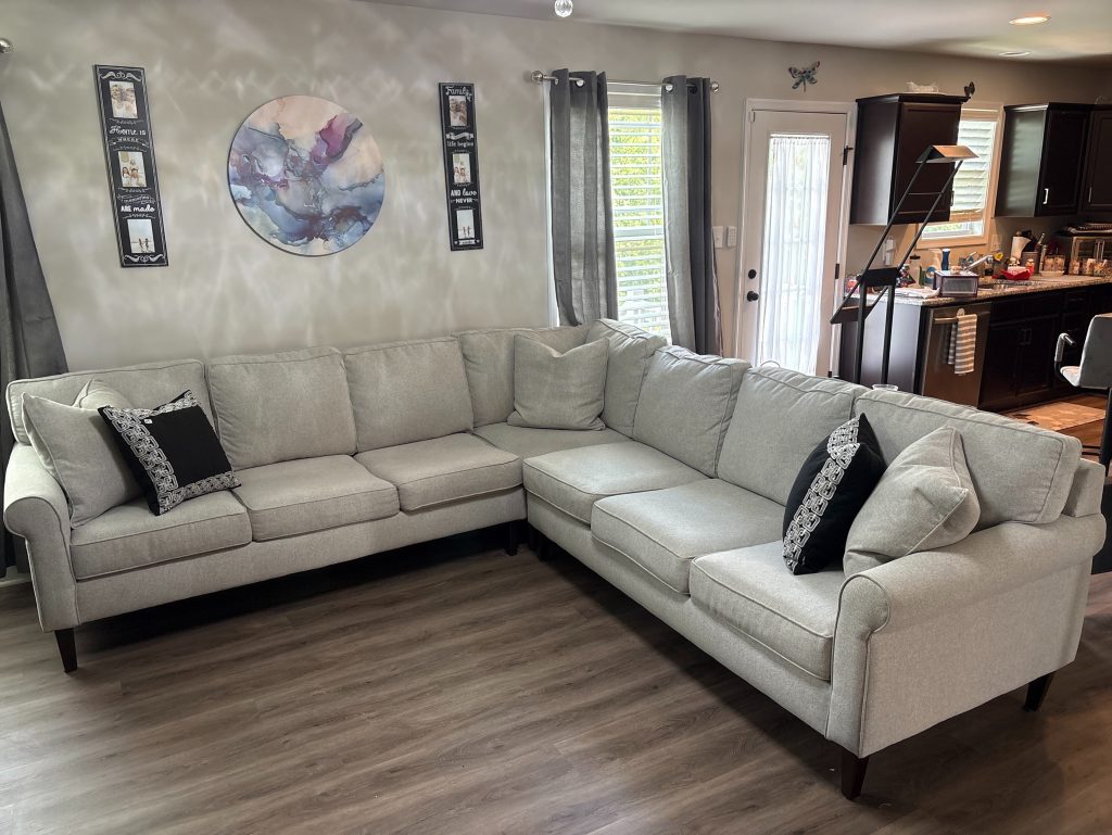 Light grey L-shaped two-piece sectional sofa with track arms, loose back cushions, and multi-cushion seating, measuring 113 inches along the longest section.