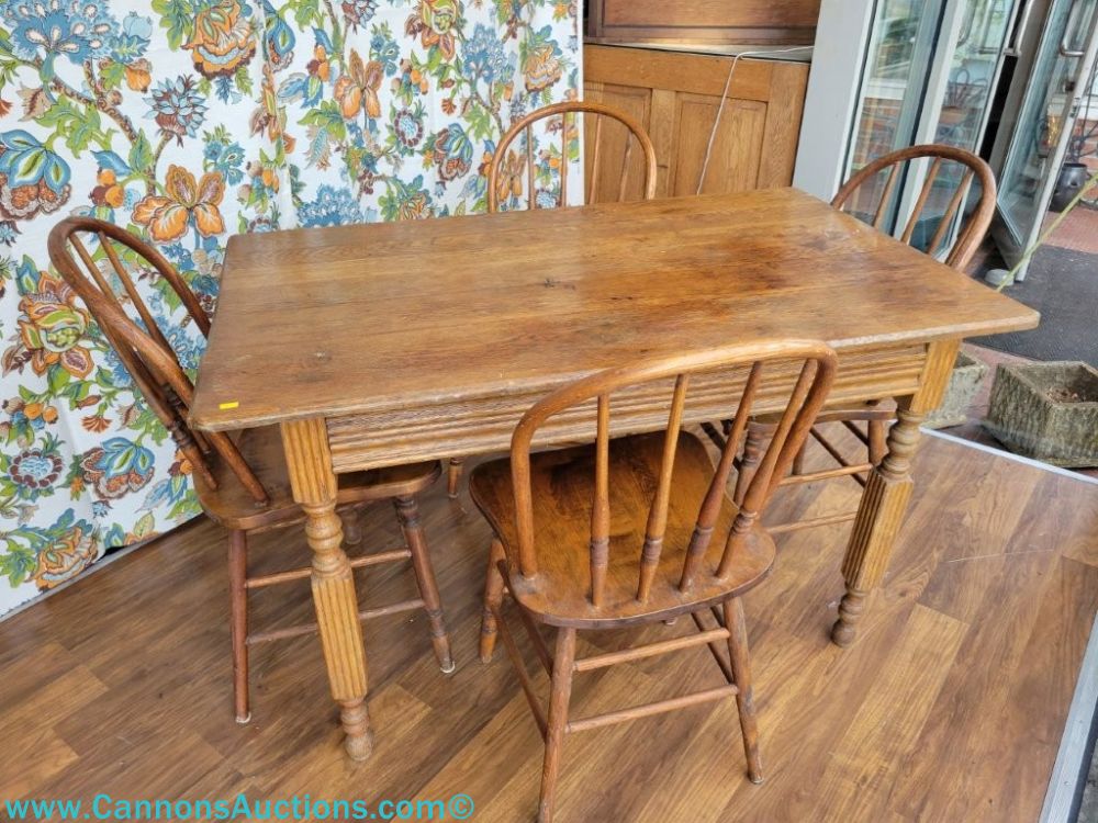Five-piece antique oak dining set with rectangular table, turned and reeded legs, shaped skirt, and four hoop-back Windsor chairs.