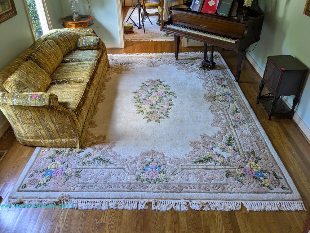 Aubusson-style hand-tufted ivory area rug with floral border and center medallion design, made in Korea, measuring 83 x 116 inches