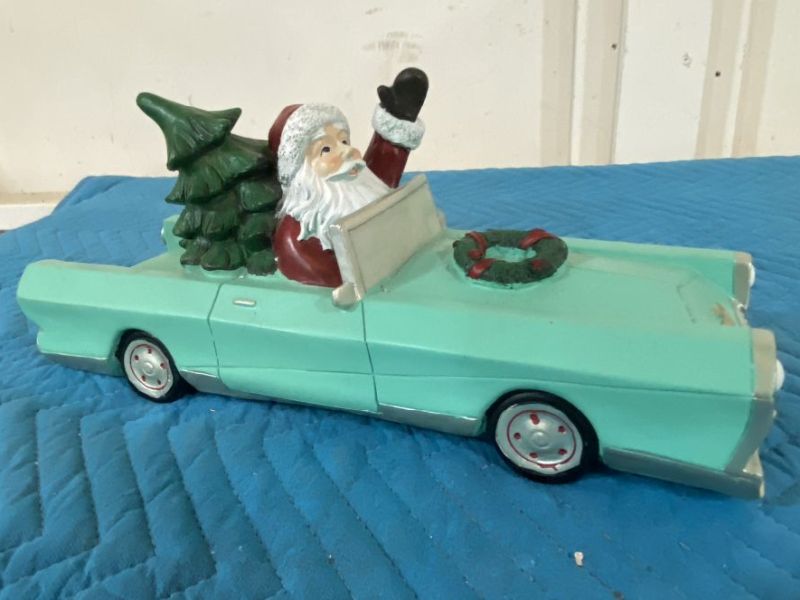 Cruising Santa Christmas decoration in a vintage turquoise convertible car with Christmas tree and wreath, 15 inches long.