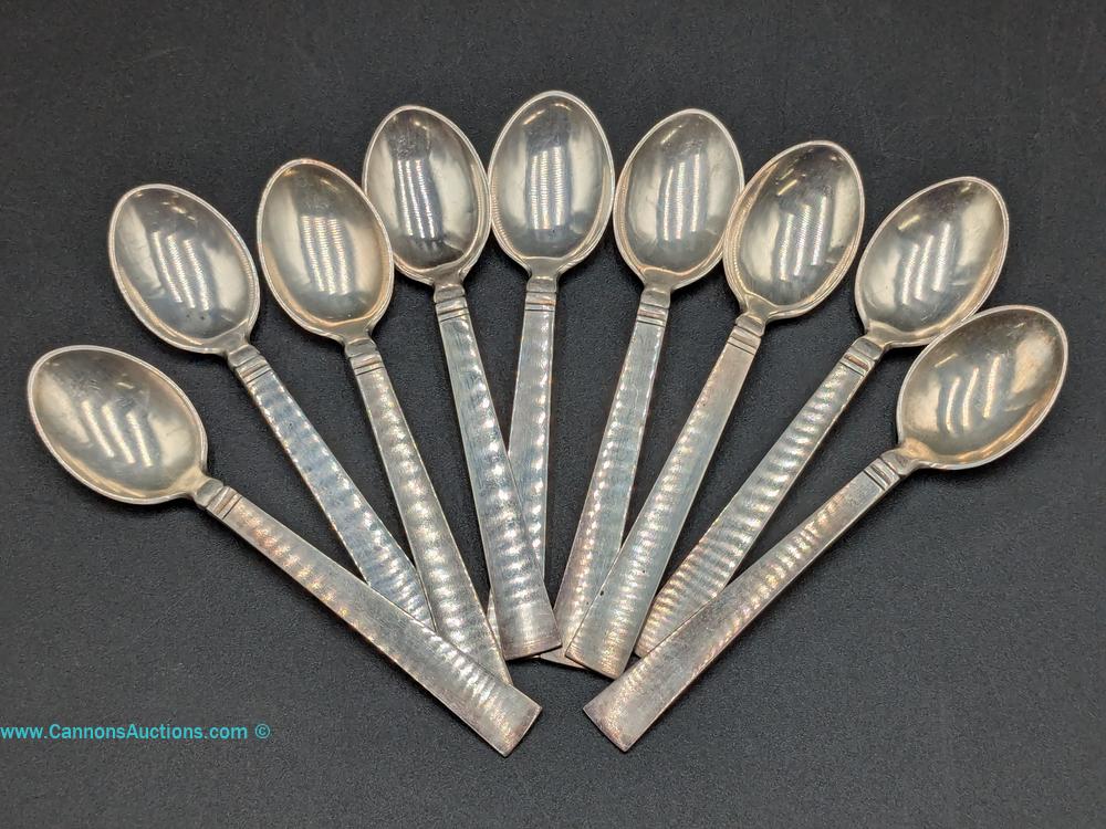 Nine Danish sterling silver demitasse spoons with textured handles, total weight 128.8 grams.