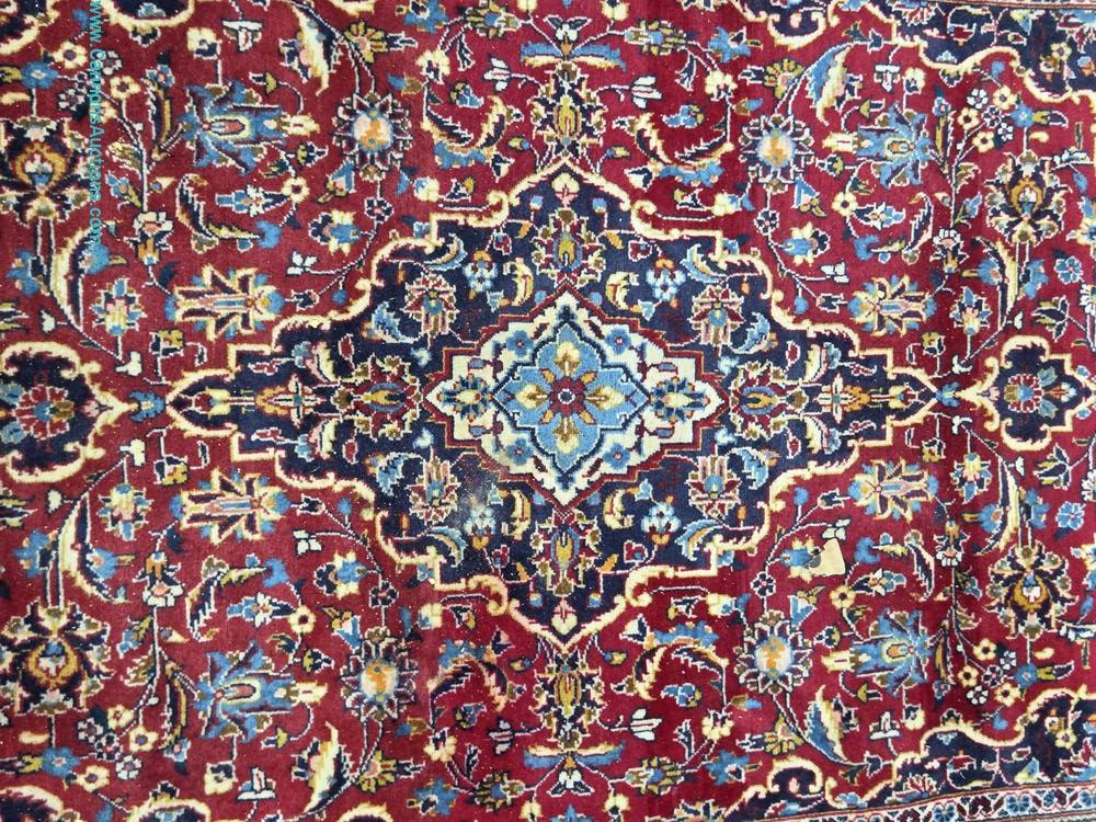 Persian Kashan hand-knotted wool rug with central medallion and floral motifs in red, blue, and cream, measuring 52 x 87 inches.