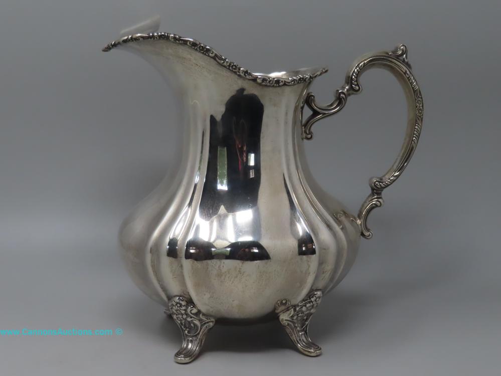 Poole “Lancaster Rose” sterling silver footed pitcher with ornate handle and floral rim, numbered 990, 10 inches tall, 1026.4 grams.