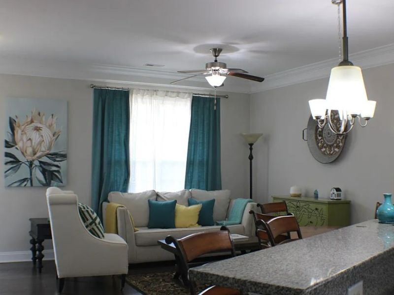 Interior of realtor-staged condo at Hawser Lane in North Chesterfield, VA, with contemporary sofa, accent chair, dining area, lighting, and home décor.