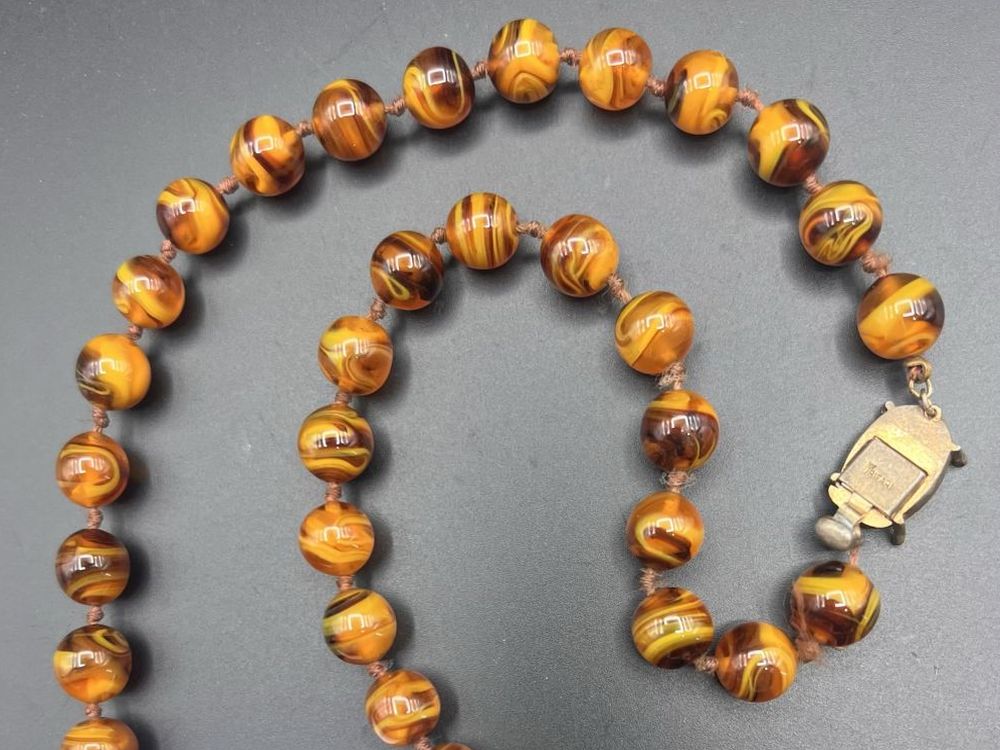 Vintage Trifari marbled amber glass beaded necklace with round knotted beads and a large gold-tone clasp