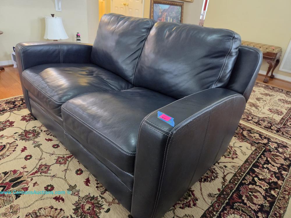 Blue leather loveseat with box cushions and white contrast stitching on block feet; measures 36" x 60" x 33"